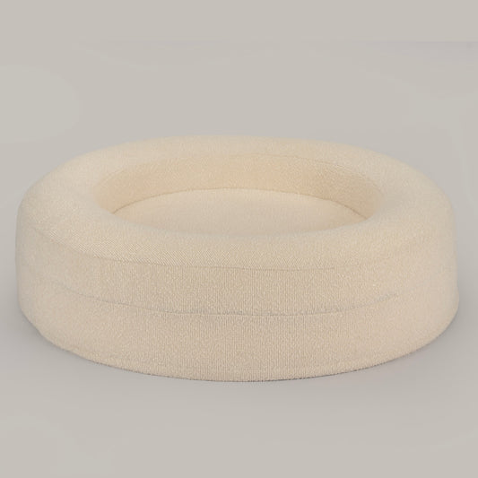 The Cocoon in cream bouclé from a high angle, showing the raised bolster walls